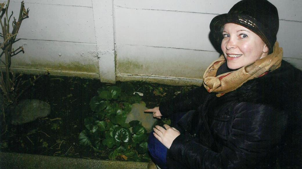 Adriana Craig ukrývá rozhlasou kešku pod kámen