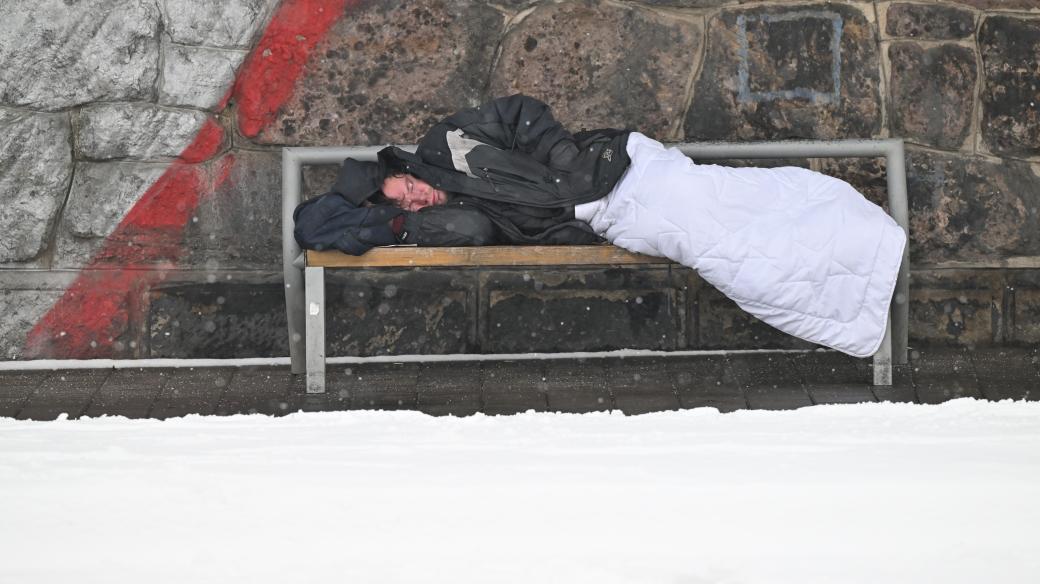 Muž spící v zimě  na lavičce (ilustr. foto)