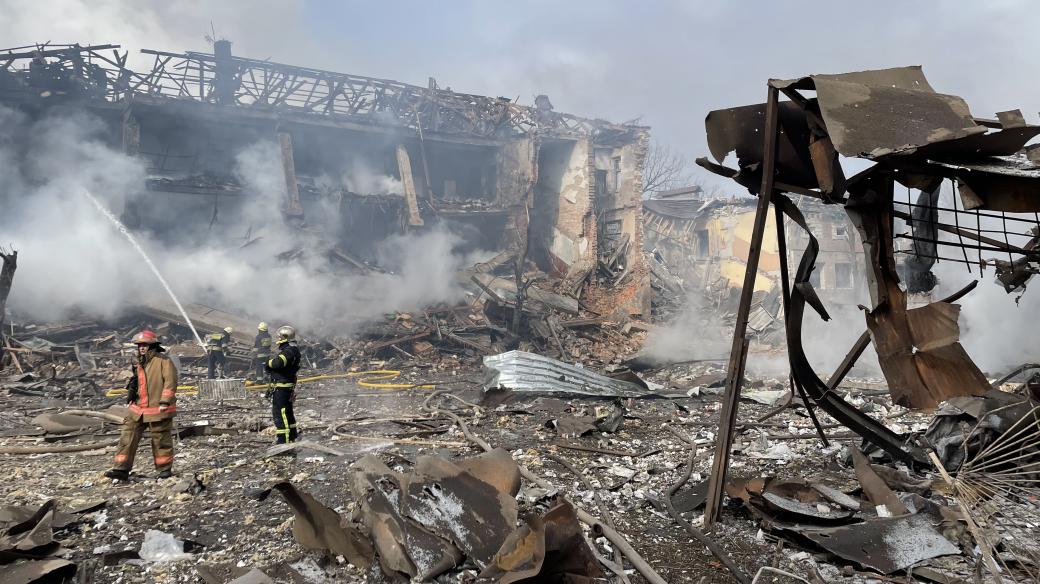 Hasiči hasí trosky budov zasažených ruským útokem