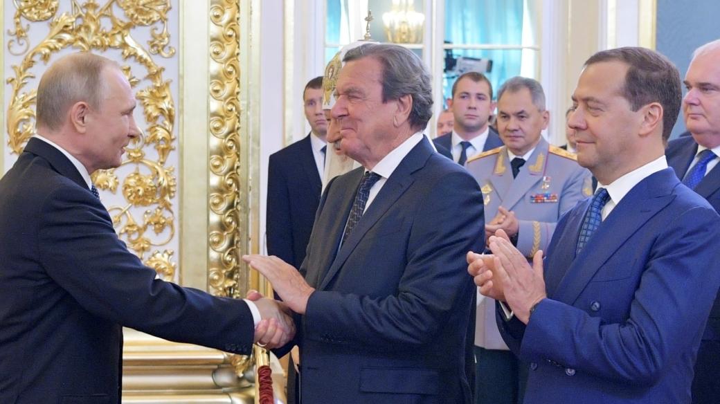 Poslední inaugurace Vladimira Putina (2018). Rukou mu potřásá Gerhard Schröder, vedle něj stojí Dmitrij Medveděv