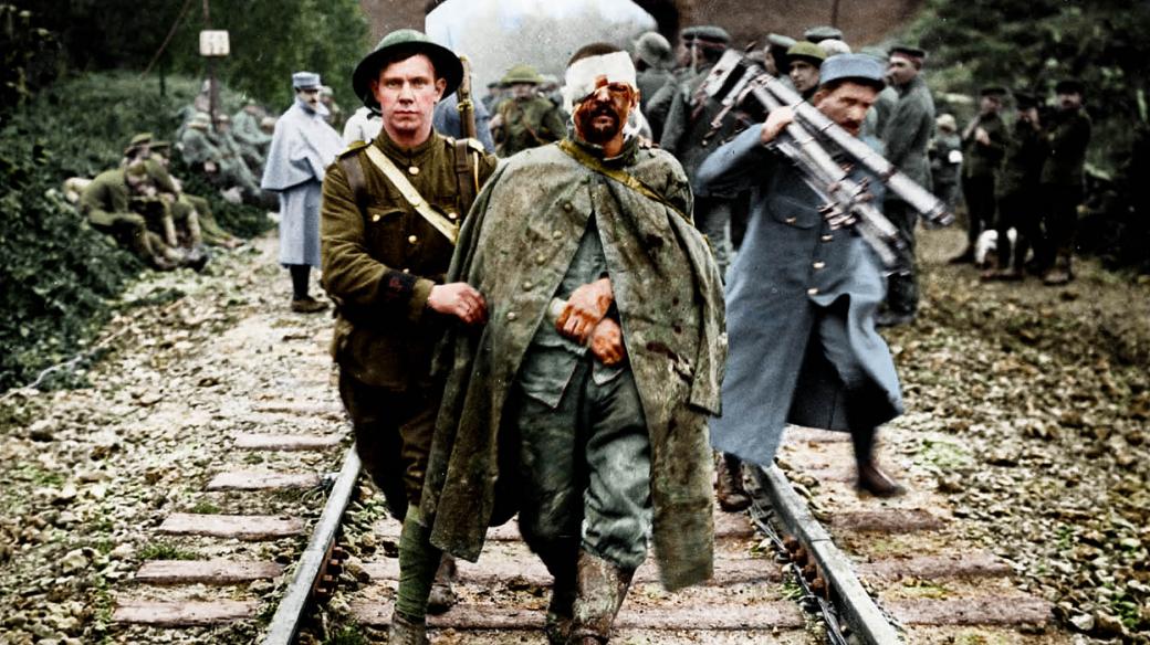 Zraněný německý voják eskortován britským vojákem