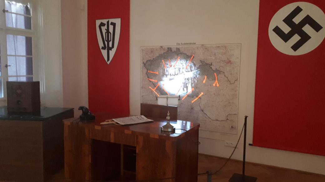 Mnichovská zrada a její důsledky jsou připomínány v místnosti zařízené jako Henleinova kancelář
