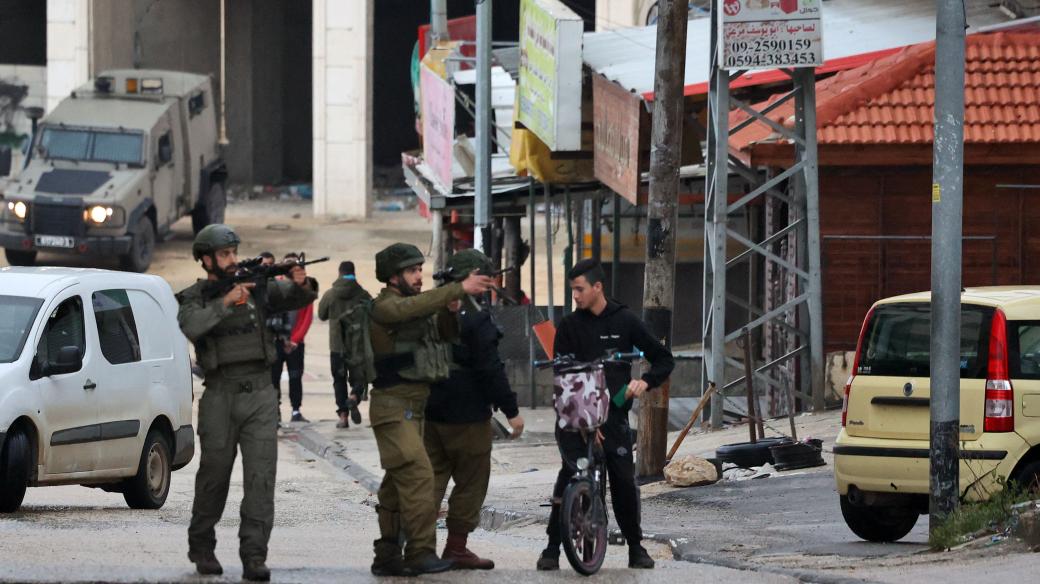 Izraelští vojáci kontrolují palestinského mladíka ve městě Huwara