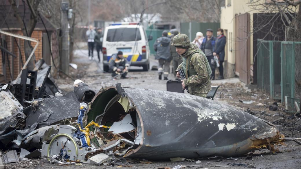 Voják ukrajinské armády prohlíží úlomky sestřeleného letadla v Kyjevě