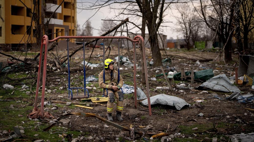 Ukrajinský hasič mezi troskami po ruském bombardování Černihivu (duben 2022)