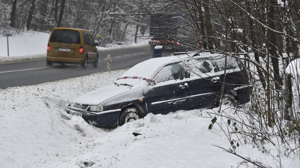 Havarované auto na silnici pokryté sněhem