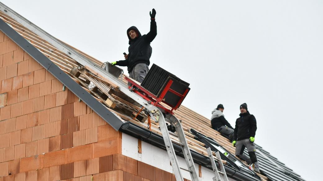 Pokrývači pokládají na střechu betonové tašky