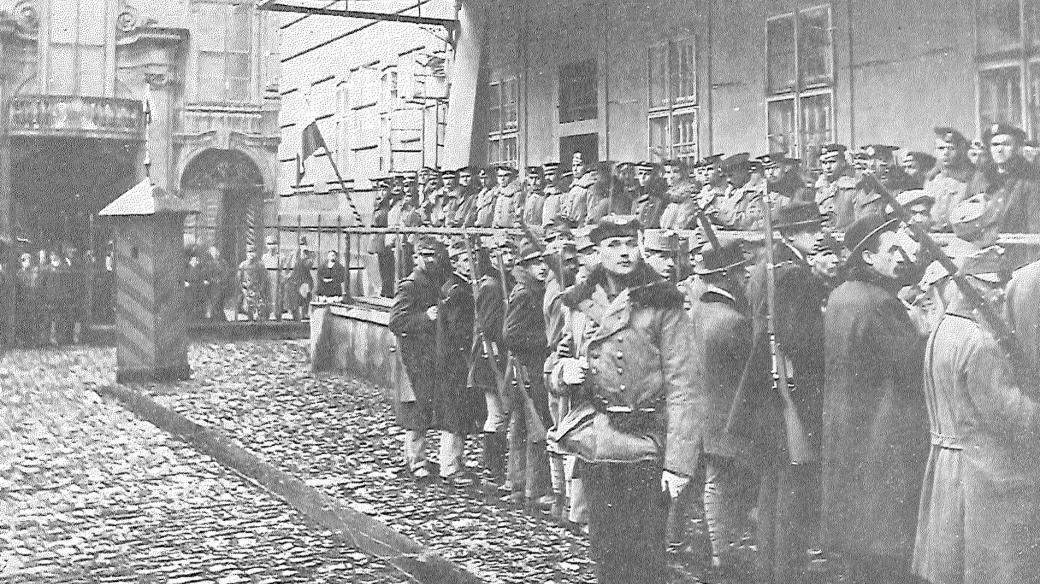 Setnina námořníků drží stráž před vojenským velitelstvím na konci října 1918 po vzniku Československa