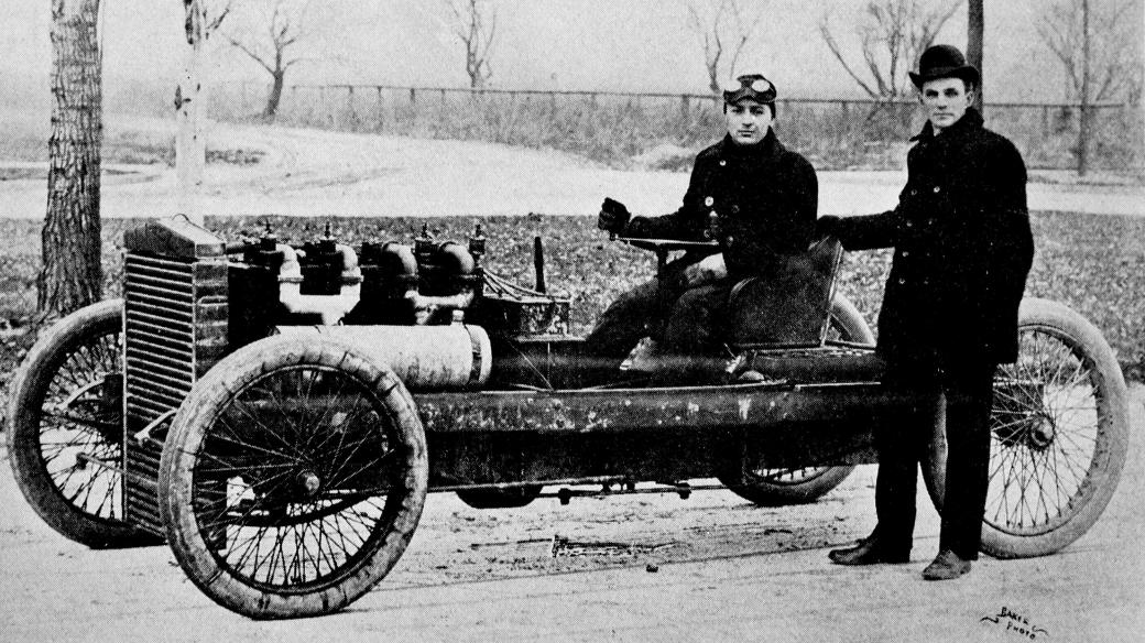Henry Ford (stojící vpravo) a Barney Oldfield se závodním vozem 999 (1902)