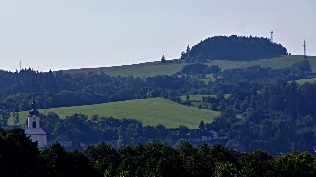 Kopec Hradisko pohledem ze silnice na Horní studénky. V pozadí vrchol Rýdrovického kopce a osada Polsko