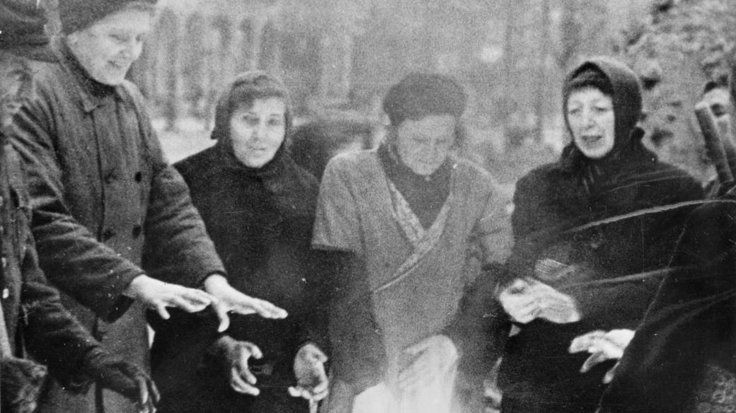 Trümmerfrauen se zahřívají u ohně během práce v zimě na přelomu let 1945 a 1946