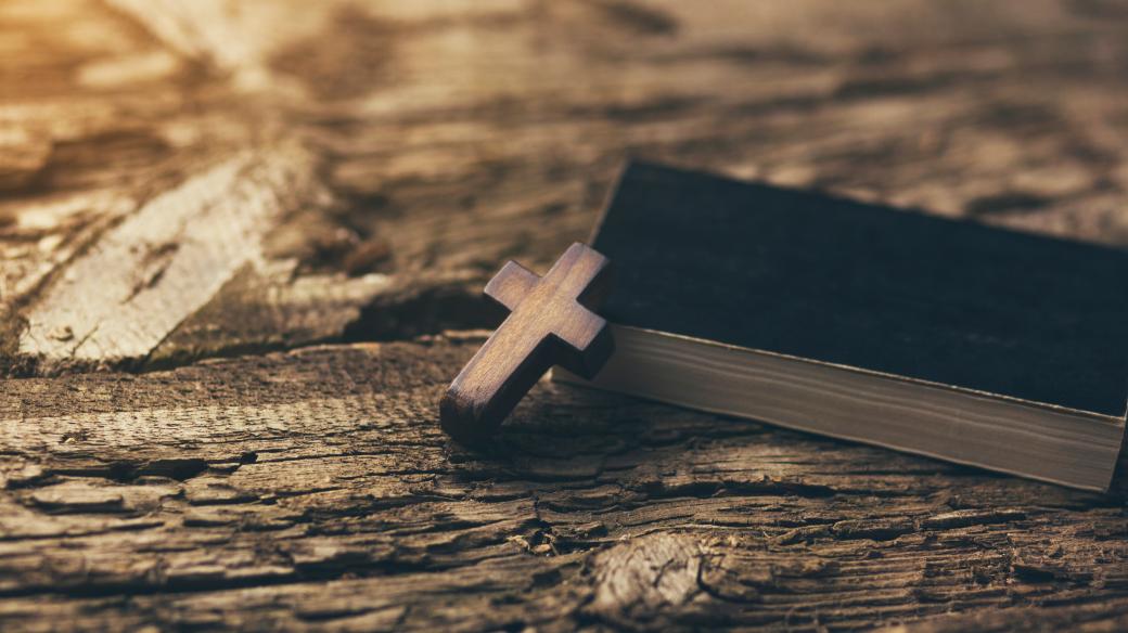 Kříž a kniha na dřevěném stole