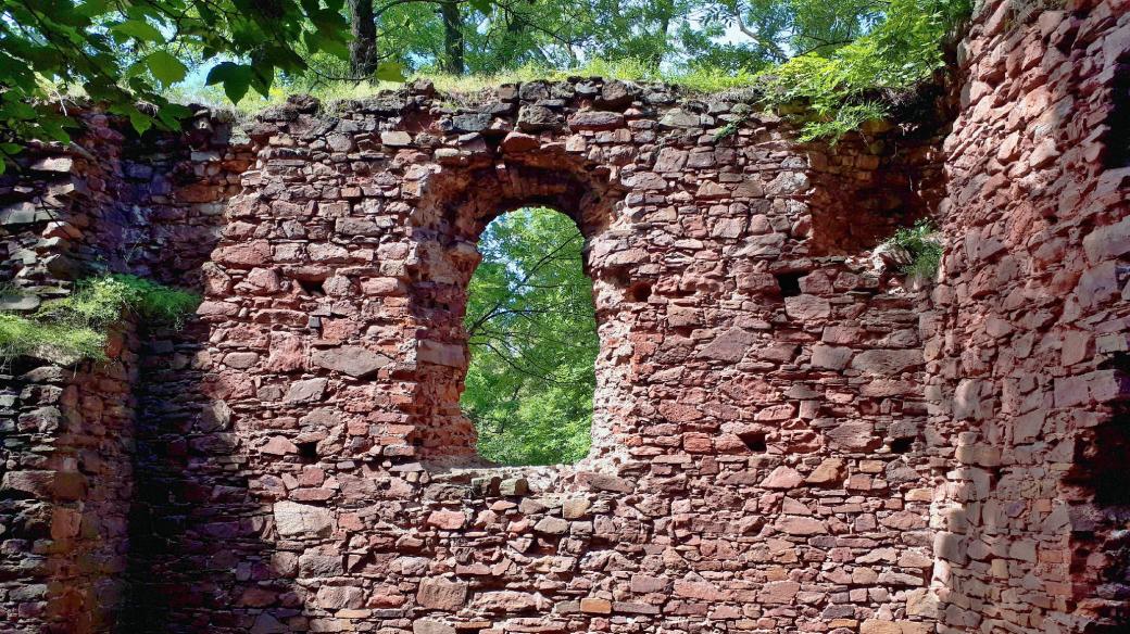 Zbytky zdí hradu zaujmou nezvykle načervenalým odstínem kamene
