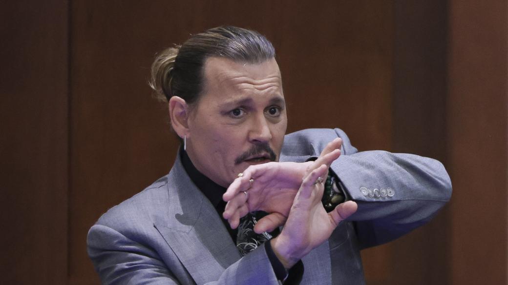 Johnny Depp během soudního přelíčení ukazuje, jak se bránil proti útokům exmanželky Amber Heard (snímek z 20. dubna 2022)
