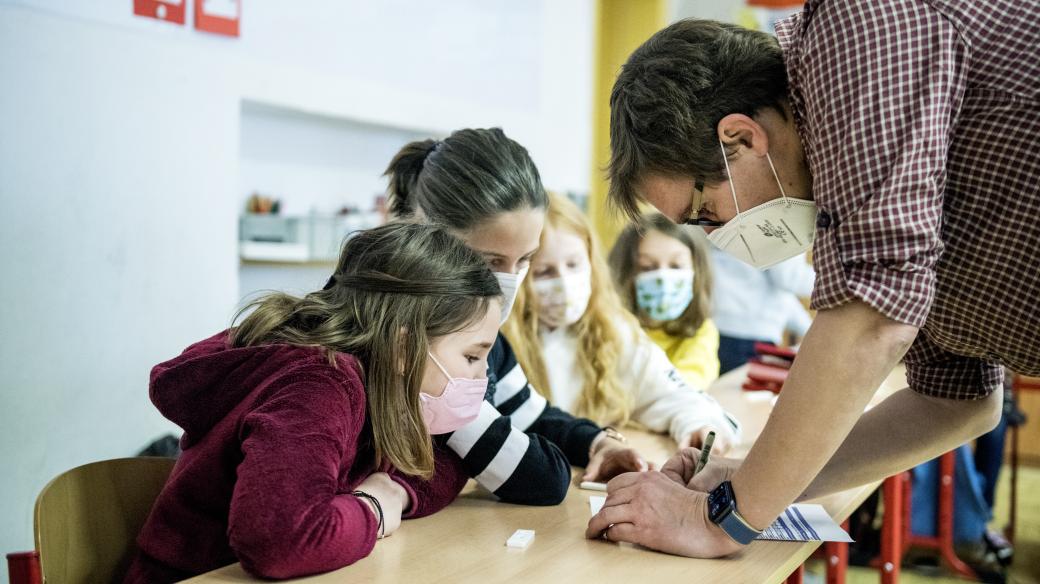 Pan učitel si zapisuje výsledky antigenního testování.