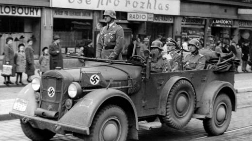 "Vše pro rozhlas": auto s policejním šéfem a říšským sekretářem protektorátu K. H. Frankem (sedící vzadu) jede kolem obchodu s rozhlasovými přijímači, po 15. březnu 1939