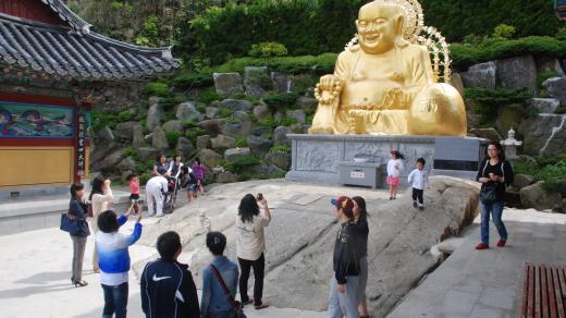 Zlatá socha Buddhy přitahuje objektivy fotoaparátů
