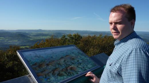 Tomáš Horyna na vrcholu Studence. Bystré oko možná na horizontu za ním najde vrch Sedlo u Úštěku nebo Milešovku