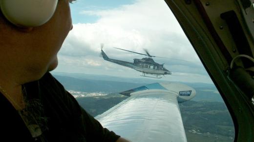 Při leteckém monitoringu Labe mezi Ústím a Děčínem potkáváme policejní vrtulník. Specialisté ze zásahové jednotky z něj kladou nálože na utržené lodi řítící se na mosty v Děčíně (15. srpen 2002)