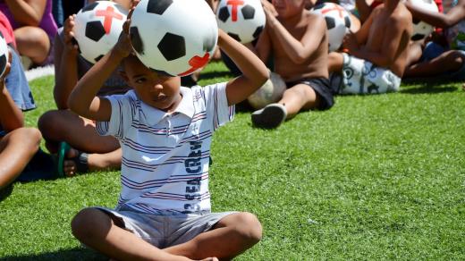 Brazílie, Rio de Janeiro. Děti z favely Jacarezinho drží míče s červenými kříži, které poukazují na peníze vydané na fotbalové mistrovství světa místo na vzdělání, zdravotnictví a zlepšení života v chudinských čtvrtích