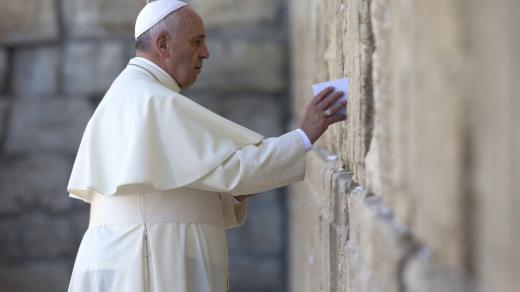 Papež František vkládá napsanou modlitbu mezi kameny ve Zdi nářků v Jeruzalémě (pondělí 26. května 2014)