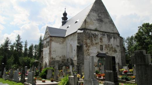 Velhratický hřbitov s tváří na stěně kostela