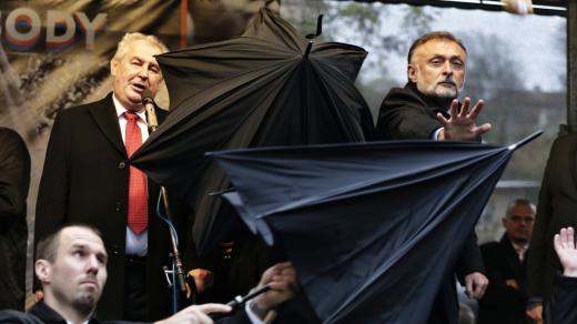 Ochranka kryje prezidenta Miloše Zemana deštníkem při protestech na Albertově