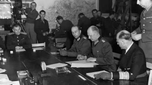 Generál Alfred Jodl v Remeši podepisuje bezpodmínečnou kapitulaci německých vojsk (po jeho levé ruce je generál admirál von Friedeburg, vpravo pak major Wilhelm Oxenius)