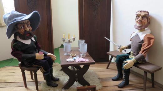 Detail scény - loupežníci hrají o svůj lup