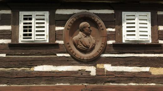 Průčelí Hankova domu v Hořiněvsi s kovovým reliéfem, který připomíná slavného rodáka a jeho životní krédo