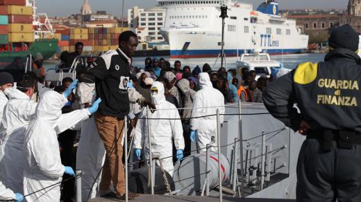 Migranti vystupují z lodi v sicilské Catanii