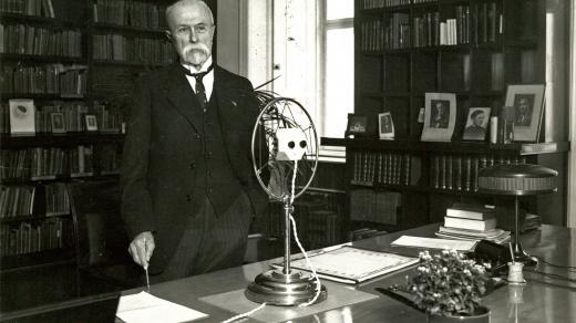 Prezident T. G. Masaryk pózuje fotografovi ve své pracovně na Pražském hradě při rozhlasovém projevu ke školákům (18. března 1932)