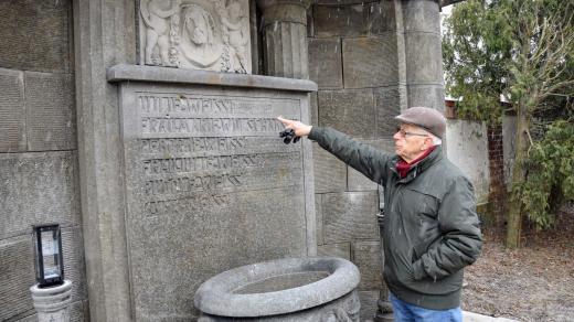 Pavel Wessely ukazuje na nápisy na opravené hrobce rodiny Weissů