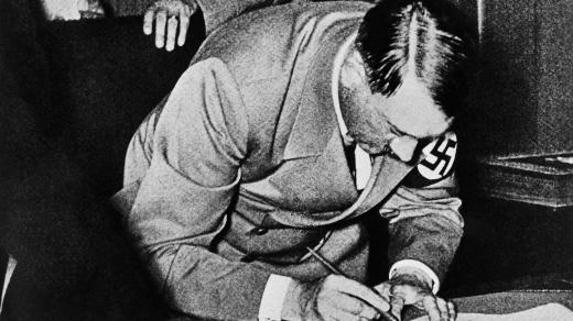 Říšský kancléř Adolf Hitler podepisuje v noci z 29. na 30. září 1938 mnichovskou dohodu