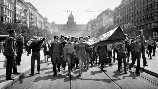 Lidé na Václavském náměstí nesou 21. srpna 1968 zkrvavenou státní vlajku