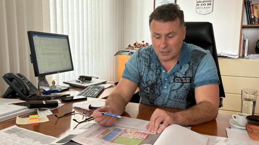 Starosta Kojetína Leoš Ptáček sedící nad projektovou dokumentací