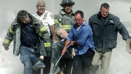 Záchranáři vynášejí P. Mychala Judge ze severní věže Světového obchodního centra po teroristických útocích z 11. září 2001