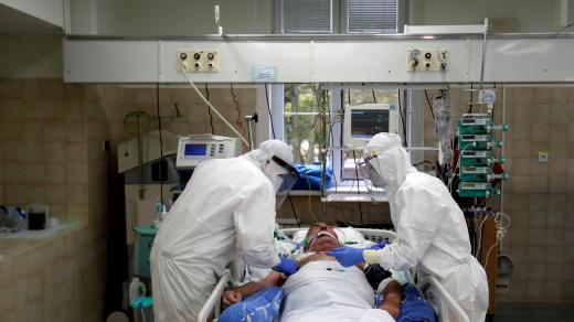 Zdravotníci u pacienta s koronavirem na JIP v nemocnici ve Slaném (foto z 13. října 2020)
