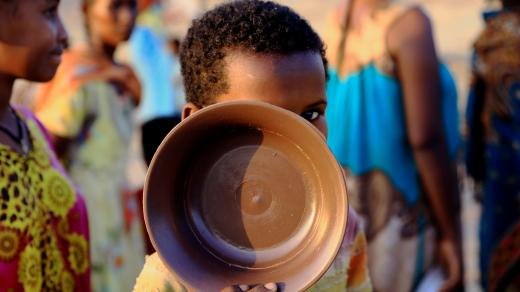 Dítě čeká na příděl stravy v táboře na hranici mezi Súdánem a Etiopií.