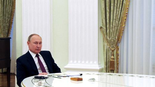 Vladimir Putin u dlouhého bílého stolu