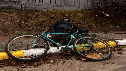 Mrtvý cyklista na ulici ukrajinského města Buča