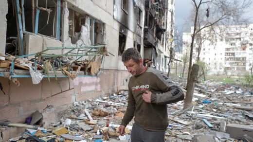 Obyvatel Severodoněcku Vjačeslav kráčí po troskách budovy poškozené vojenským útokem