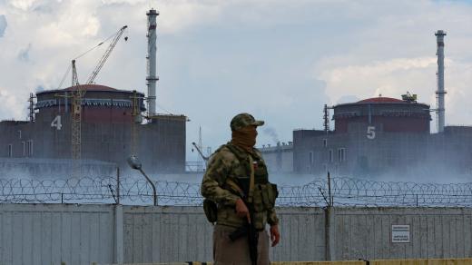 Voják s ruskou vlajkou na uniformě poblíž Záporožské jaderné elektrárny