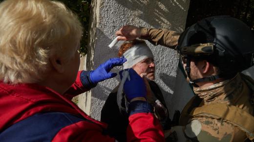 Zdravotníci ošetřují ženu, která byla zraněna v důsledku útoku ruských raket na Kyjev