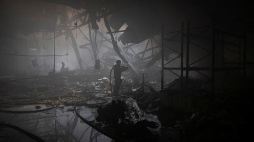 Hasič pracuje na místě, kde byla tiskárna zasažena ruskými raketami během ruského útoku na Charkov na Ukrajině 23. května 2024