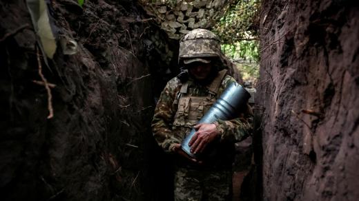 Ukrajinský voják nesoucí munici do houfnice při obraně proti ruskému útoku v Doňeckém regionu