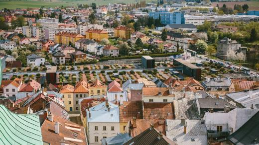 Pohled na město z věže kostela sv. Jakuba Většího. V popředí staré město, uprostřed plochá střecha nákupního centra postaveného na místě původních historických podniků