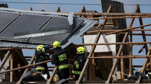 Polští hasiči opravují střechu domu v obci Wyryki, která byla poničena při snaze zneškodnit ruské drony