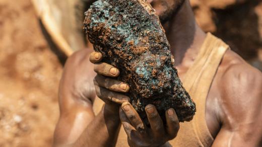 Horník v Demokratické republice Kongo drží kobaltový kámen.