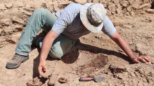 Vybírání střepů dna zásobnice ze základů zkoumaného objektu